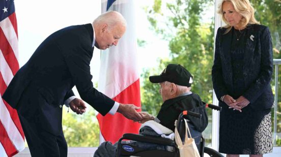 US President Joe Biden shakes hands with a US WWII veteran as US First Lady Jill Biden