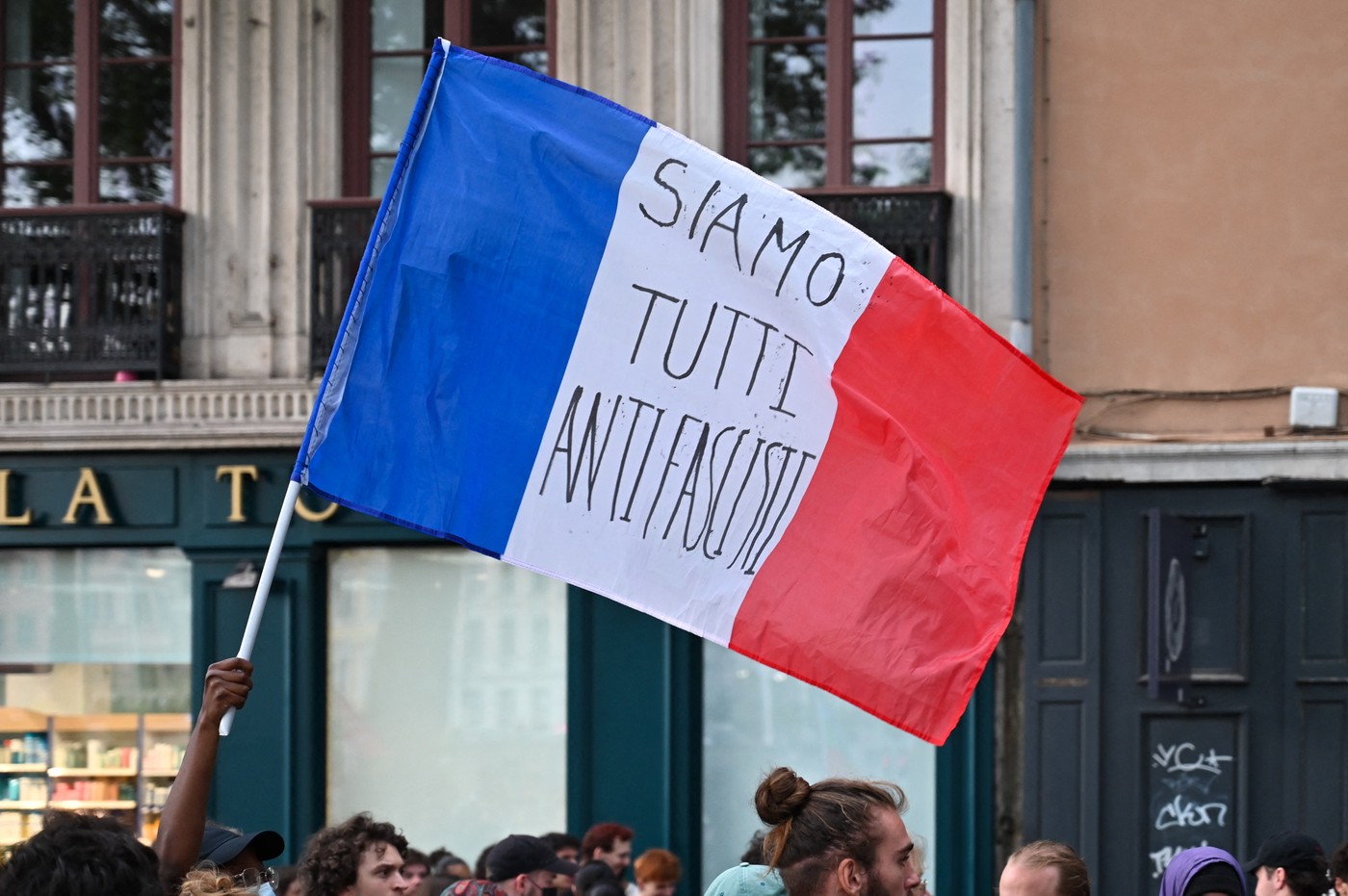 A French flag bearing the words SIAMO TUTTI ANTIFASCISTI