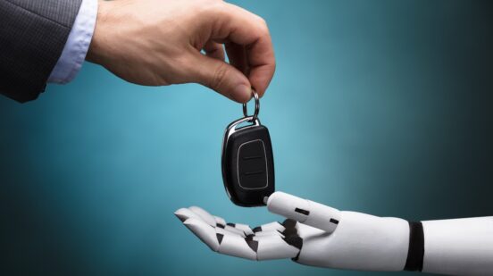 Close-up Of A Businessperson's Hand Giving Car Key To Robot