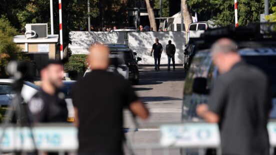 Israeli security forces gather behind a barrier across a street leading to Prime Minister Benjamin Netanyahu's residence in Caesarea