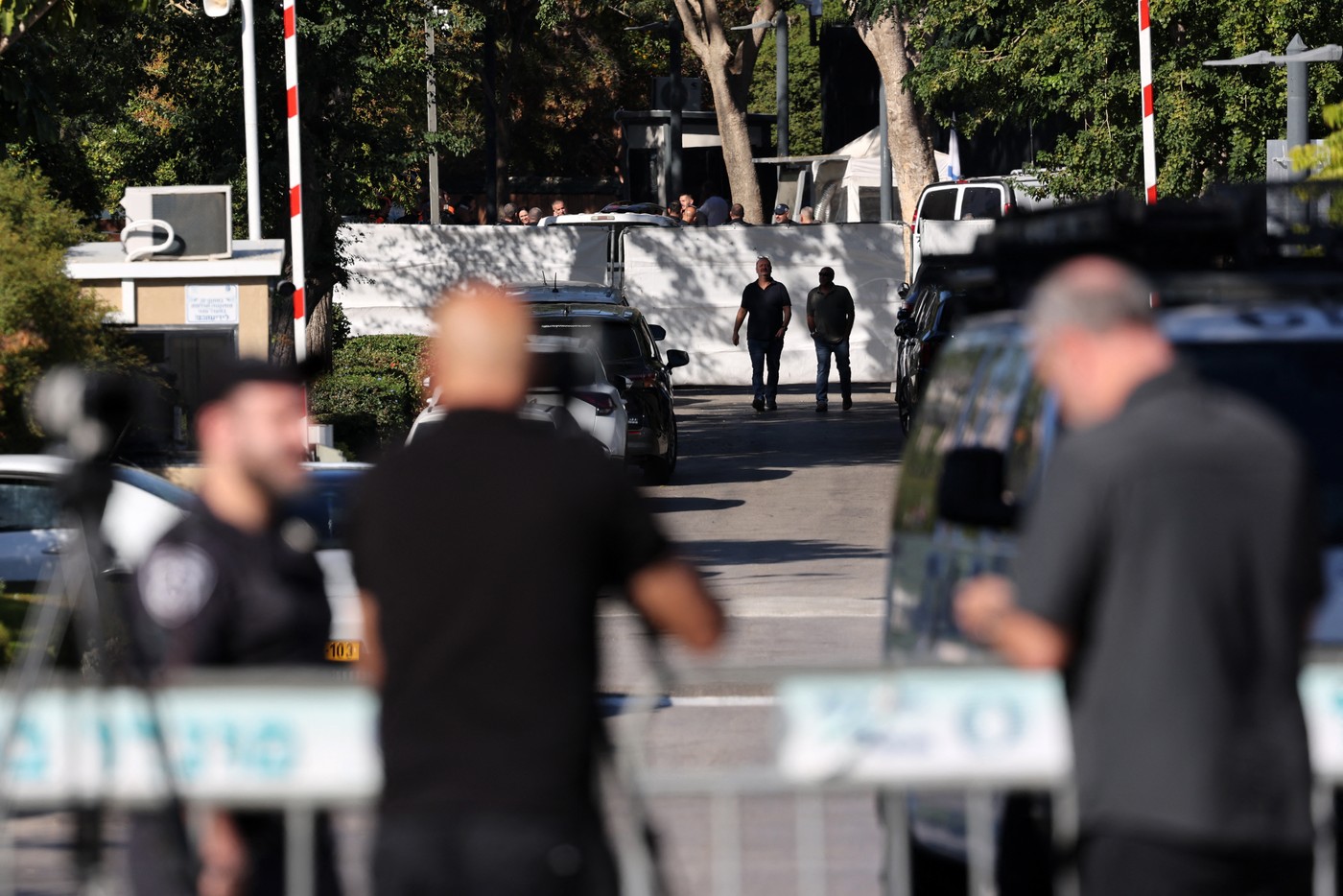 Israeli security forces gather behind a barrier across a street leading to Prime Minister Benjamin Netanyahu's residence in Caesarea